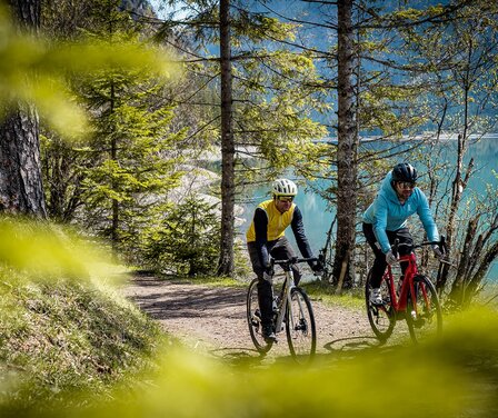 Blick auf zwei Männer bei einer Gravelbiketour um einen See | © TVB Naturparkregion Reutte