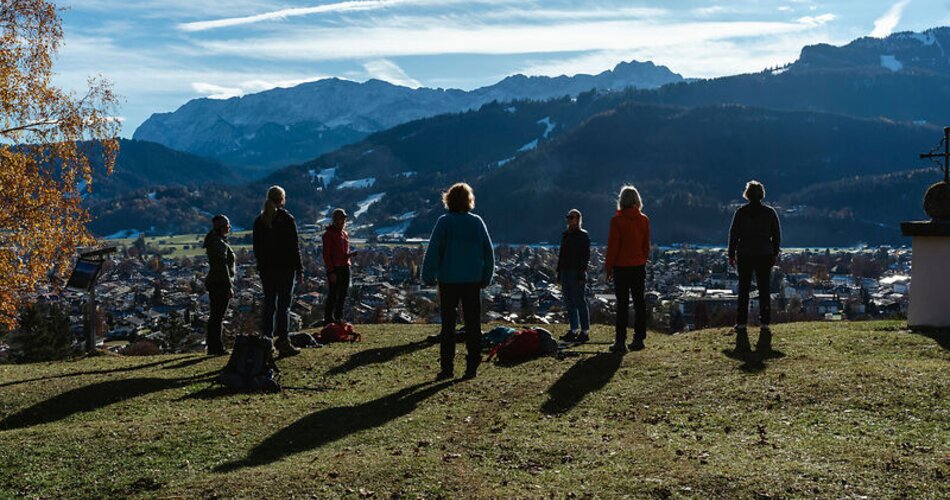 Atemübung am Grasberg Kriegergedächtniskapelle mit Blick auf Garmisch-Partenkirchen | © GaPa Tourismus GmbH/Laura Schmatz