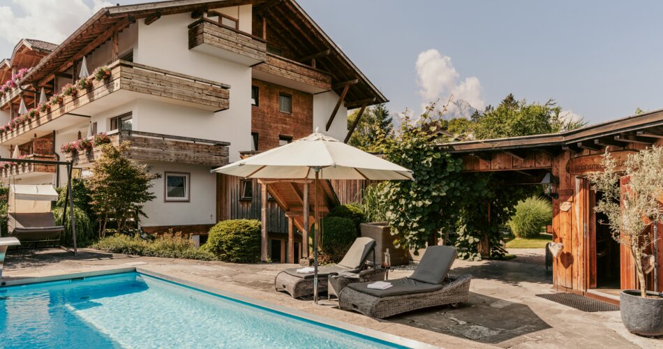 Blick in den Garten mit Außenpool im Hotel Staudacher Hof in Garmisch-Partenkirchen | © Staudacher Hof