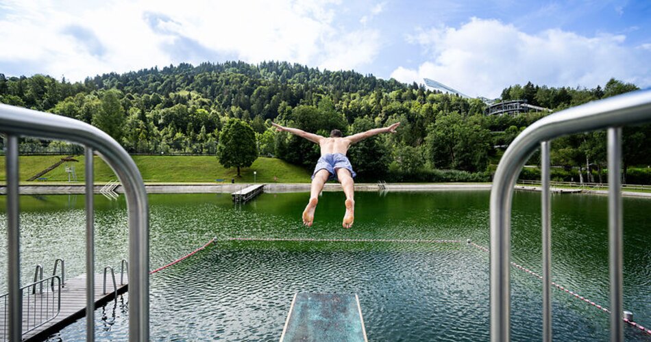 Mann springt vom Sprungturm im Kainzenbad in Garmisch-Partenkirchen | © GaPa Tourismus GmbH/ stadlerphoto.com