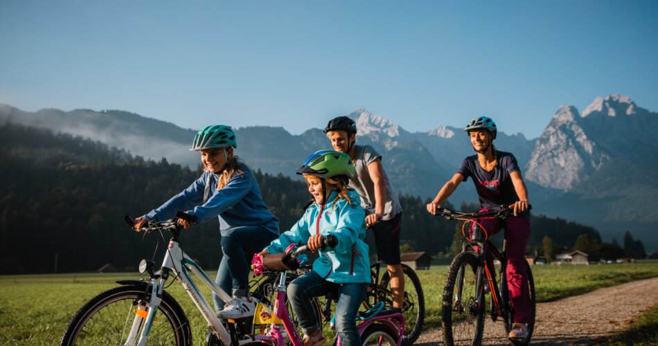 Blick auf eine Familie bei einer Radtour durch Garmisch-Partenkirchen | © Zugspitz Arena Bayern Tirol/ Thomas Marzusch