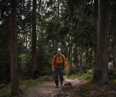 Blick auf einen Bergsteiger mit Stirnlampe im Wald in Garmisch-Partenkirchen | © GaPa Tourismus GmbH/ Roadtrip the World