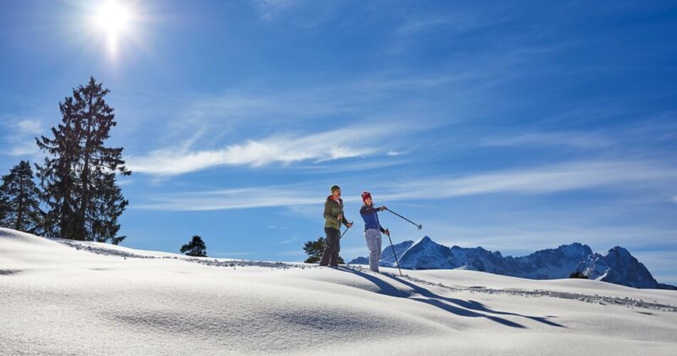 Blick auf ein Paar bei einer Schneeschuhwanderung in einer verschneiten Landschaft in Garmisch-Partenkirchen | © GaPa Tourismus GmbH/Christian Stadler
